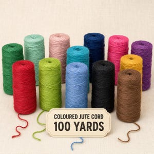 May include: A collection of fourteen spools of coloured jute cord in various shades including red, green, lime, mint, pink, blue, yellow, brown, black, and purple. A rectangular label in the foreground reads COLOURED JUTE CORD 100 YARDS.