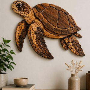 May include: A wall-mounted sea turtle sculpture crafted from segmented pieces of wood in varying shades of light and dark brown. The turtle is depicted in a swimming position with detailed scale patterns on its head, flippers, and shell.