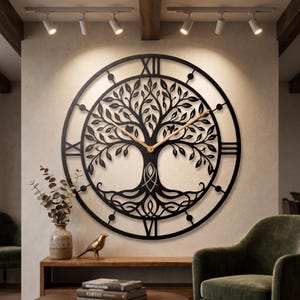 Könnte beinhalten: Eine große, runde Wanduhr mit einem schwarzen Metallausschnitt-Design eines Lebensbaums mit komplexen Ästen und Wurzeln. Das Zifferblatt zeigt römische Ziffern am äußeren Ring und zwei dünne, helle Zeiger aus Holz.