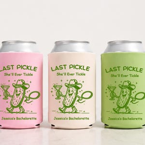 May include: Three cylindrical foam can coolers in light pink, cream, and light green. Each features a green graphic of a winking pickle wearing a cowboy hat and boots, holding a martini glass and lasso, with the text "LAST PICKLE She'll Ever Tickle" and "Jessica's Bachelorette".