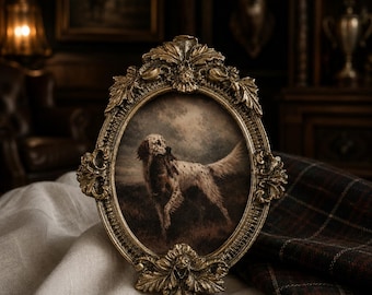 May include: An oval-shaped picture frame with an ornate, antique gold-colored finish featuring intricate leaf and floral carvings. The frame holds a print of a white and brown spotted hunting dog standing in a field under a cloudy, dark sky.
