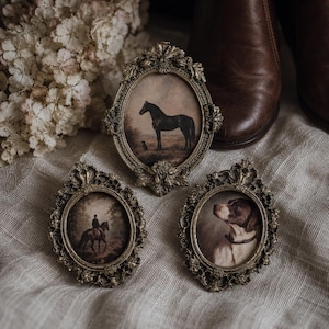 May include: Three oval picture frames with ornate, antique-style metallic gold detailing. The top frame displays a horse in a field, the bottom left shows a person riding a horse, and the bottom right features a portrait of a brown and white dog.