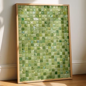 Könnte beinhalten: Ein rechteckiges Wandbild bestehend aus einem Raster kleiner, quadratischer Glastiles in verschiedenen Nuancen von Hellgrün, Oliv und Limette. Das Mosaik ist in einen schlichten, hellen Holzrahmen gefasst und erzeugt eine texturierte Oberfläche.