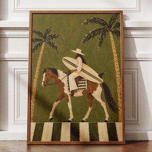 Peut inclure: Une impression d'art encadrée représentant une personne portant un chapeau à larges bords et des vêtements blancs, montant un cheval brun et blanc tout en portant une planche de surf. Deux palmiers se dressent sur un fond vert olive uni.