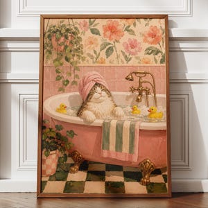 Peut inclure: Une impression d'art encadrée représentant un chat avec une serviette rose sur la tête, se relaxant dans une baignoire rose à pieds griffus remplie de bulles et de trois canards en caoutchouc jaunes, avec papier peint floral et plantes.