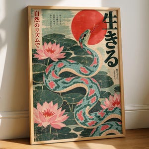 May include: A framed art print featuring a teal snake with pink patterned scales winding through a pond of dark green lily pads and pink lotus flowers. A large red sun sits in the background with Japanese text characters printed on the poster.