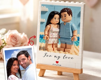 Op de afbeelding: Een portret van bouwstenen op een houten ezel met twee figuren, één met lang donker haar in een bloemetjestop en één met kort bruin haar in een blauw overhemd. Het frame bevat de tekst For my love, een rood hartje en de datum 8.3.2026.