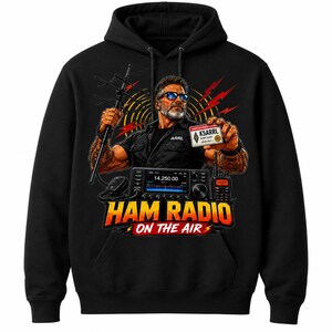 May include: A black hooded sweatshirt featuring a graphic of a person with a beard and sunglasses holding an antenna and an amateur radio licence card. Below, a radio transceiver is displayed with the text HAM RADIO ON THE AIR in bold letters.