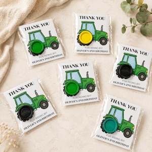 May include: Five party favor cards in clear plastic sleeves, each featuring a green tractor illustration, the text THANK YOU, FOR RIDING BY!, and OLIVER'S 2ND BIRTHDAY. Each card has a circular Play-Doh container attached as a tractor wheel.