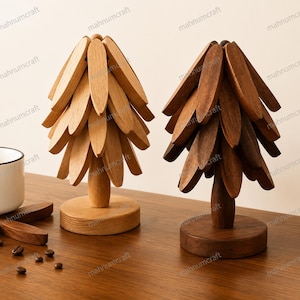 May include: Two decorative wooden tree sculptures, one in a light natural wood finish and the other in a darker stained wood finish. Each tree features a central trunk, a circular base, and multiple layered, petal-shaped wooden branches.