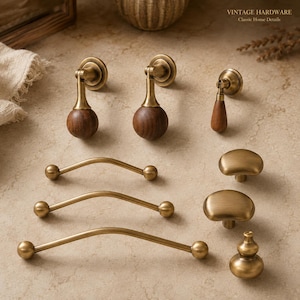 May include: A collection of cabinet hardware including three curved brass drawer pulls, two brass and wood drop pulls, one small wood drop pull, two smooth brass knobs, and one gourd-shaped brass knob. Text reads VINTAGE HARDWARE Classic Home Details.