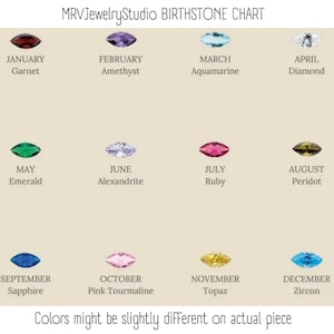 May include: A MRVJewelryStudio birthstone chart displaying twelve marquise-cut gemstones arranged in three rows. Each stone corresponds to a month and name: January Garnet, February Amethyst, March Aquamarine, April Diamond, May Emerald, June Alexandrite, July Ruby, August Peridot, September Sapphire, October Pink Tourmaline, November Topaz, and December Zircon. Text at the bottom states: Colors might be slightly different on actual piece.