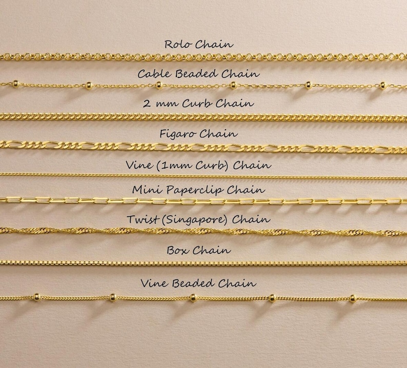 May include: A collection of eight gold-toned metal chains arranged horizontally, labeled as Rolo Chain, Cable Beaded Chain, 2 mm Curb Chain, Figaro Chain, Vine (1mm Curb) Chain, Mini Paperclip Chain, Twist (Singapore) Chain, Box Chain, and Vine Beaded Chain.