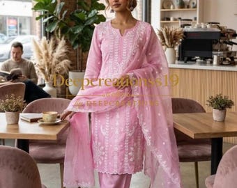 Op de afbeelding: Een lichtroze driedelige outfit bestaande uit een tuniek met lange mouwen, een broek met rechte pijpen en een transparante dupatta. De tuniek en broek zijn voorzien van wit bloemenborduurwerk. De dupatta heeft een bijpassende rand.
