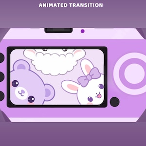 Peut inclure: Un appareil photo numérique violet clair avec un écran affichant une illustration de dessin animé d'un mouton blanc, d'un ours violet clair et d'un lapin blanc avec un nœud violet. Le texte ANIMATED TRANSITION apparaît en blanc en haut.