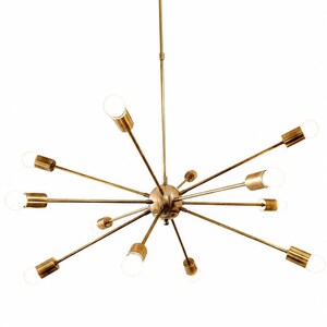 May include: A brass-toned sputnik chandelier featuring a central sphere with multiple radiating arms. Each arm terminates in a cylindrical socket holding a glowing light bulb. The fixture is suspended from a single vertical rod attached to a circular ceiling canopy.