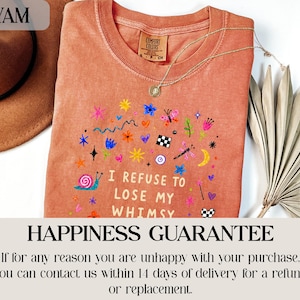 Orange t-shirt with whimsical graphic and text "I refuse to lose my whimsy."
