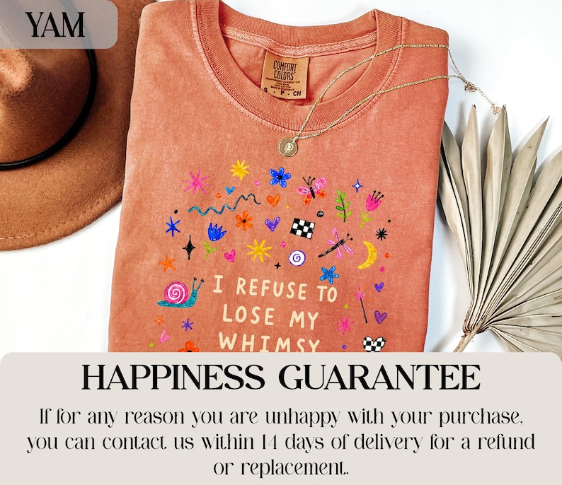 Orange t-shirt with whimsical graphic and text "I refuse to lose my whimsy."