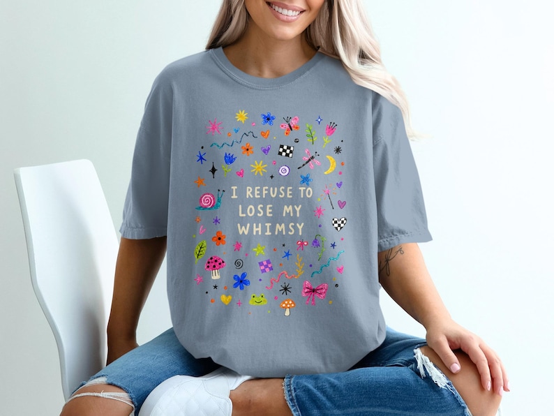 T-shirt with colorful whimsical doodles and text "I REFUSE TO LOSE MY WHIMSY."