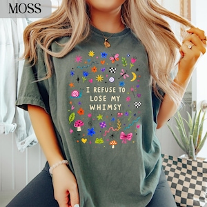 Green t-shirt with colorful whimsical graphics and "I REFUSE TO LOSE MY WHIMSY" text.