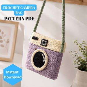 Puede incluir: Un bolso de cámara de ganchillo con cuerpo color lavanda, parte superior y detalle de lente color crema, y centro de lente negro. Tiene una correa larga color verde salvia. El texto CROCHET CAMERA BAG PATTERN PDF e Instant Download es visible.
