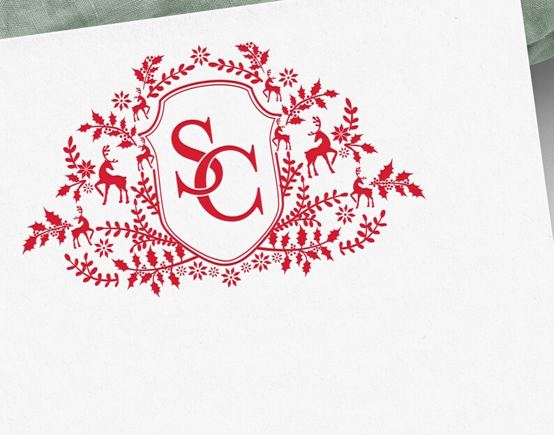 Op de afbeelding: Rood monogram met de letters "SC" in een wit schild omringd door een krans van rode hulstbladeren, bessen en rendieren.