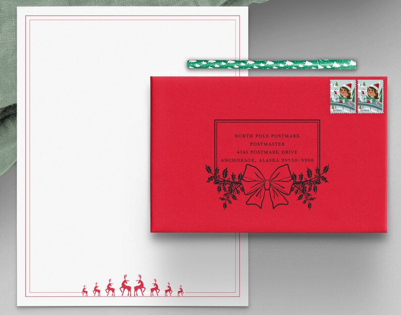 Op de afbeelding: Een rode envelop met een zwart-witte postzegel van het postkantoor van de Noordpool. De postzegel vermeldt "North Pole Postmark Postmaster 4141 Postmaster Drive Anchorage, Alaska 99530-9998". De envelop heeft twee kerstzegels met afbeeldingen van elven.