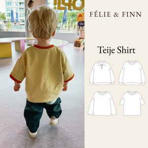 Puede incluir: Una camiseta amarilla de manga corta con cuello y puños rojos, combinada con pantalones verde oscuro y zapatillas blancas. La imagen incluye el texto FÉLIE & FINN Teije Shirt y cuatro dibujos de líneas en blanco y negro de variantes.
