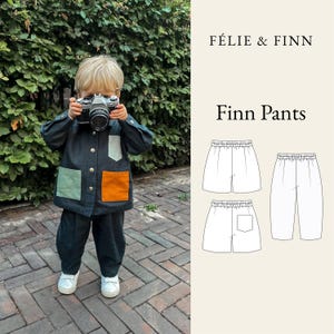 May include: A dark charcoal jacket with a light green chest pocket and two lower pockets in light green and orange, paired with matching dark charcoal pants. The image includes the text FÉLIE & FINN Finn Pants and a technical line drawing of shorts and pants.