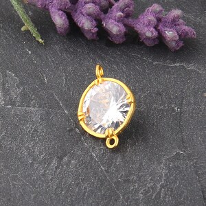 May include: Gold-tone pendant with a clear round crystal and two jump rings.