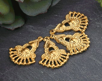 May include: Four gold-tone metal decorative embellishments with intricate designs. Each embellishment features a circular center with a raised design and a fan-shaped outer edge.