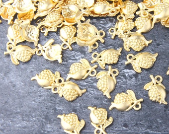 May include: A large group of gold-toned metal charms shaped like pomegranates with leaves. The charms have a textured surface and are perfect for jewelry making.