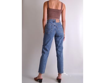 May include: A pair of blue denim jeans with a high waist and a straight leg fit. The jeans have a classic five-pocket style and a light wash.