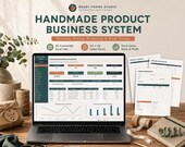 A silver laptop displays a green and white "Handmade Business Dashboard" spreadsheet, with three paper forms titled "Product Catalog," "Order Worksheet," and "Pricing Calculator" to its right.