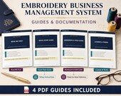 Four printed guides for the "Embroidery Business Management System" are arranged on a surface, with a pen, glasses, and embroidery thread spools nearby.