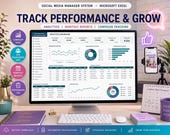 A desktop monitor shows an Excel analytics dashboard with charts and data, next to a smartphone on a tripod, surrounded by office supplies and a plant.