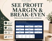 A laptop displays a profit margin and break-even control room dashboard spreadsheet.