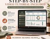 A laptop screen plays a video tutorial with a table of contents sidebar showing a setup walkthrough and dashboard overview, next to a notebook and spray bottle.