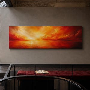 Op de afbeelding: Een groot, horizontaal rechthoekig schilderij op canvas dat een levendige zonsondergang boven een kalm wateroppervlak weergeeft. Het kunstwerk bevat intense tinten oranje, rood en geel, met zachte, vervaagde wolken in de lucht en een reflecterend oppervlak.