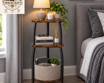 May include: A three-tier corner shelf with a dark wood finish and black metal frame. The top shelf holds a lamp and a candle. The middle shelf holds books titled The Kinfolk Home and At Home, and a reed diffuser. The bottom shelf holds a fabric basket.