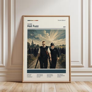 May include: A framed movie poster for the 2007 film Hot Fuzz by Edgar Wright. The poster features two police officers walking on a path with a church in the background and a group of hooded figures. The text includes the title, year, and cast names.