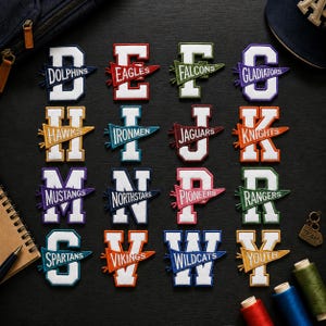 Pode incluir: Uma coleção de dezasseis emblemas bordados em forma de letra dispostos numa grelha, cada um com uma bandeirola de estilo desportivo com nomes de equipas como Dolphins, Eagles, Falcons, Gladiators, Hawks, Ironmen, Jaguars, Knights, Mustangs, Northstars, Pioneers, Rangers, Spartans, Vikings, Wildcats e Youth.