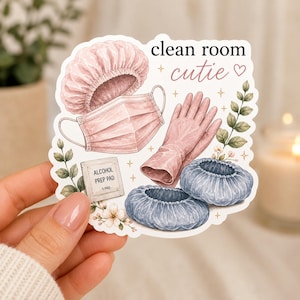 May include: A die-cut sticker featuring the text clean room cutie with illustrations of a pink bouffant cap, a pink face mask, pink gloves, two blue shoe covers, an alcohol prep pad, and green leafy sprigs with small white flowers.