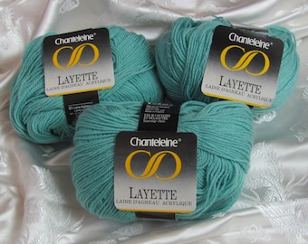 May include: Three skeins of teal blue yarn labeled "Chanteleine Layette Laine d'agneau acrylique" with a gold infinity symbol.
