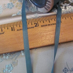 K&ouml;nnte beinhalten: Ein Holzlineal mit den Worten "Falcon", "Auburn Maine" und "Made in U.S.A." darauf gedruckt. Ein dunkelgr&uuml;nes Band liegt auf dem Lineal.