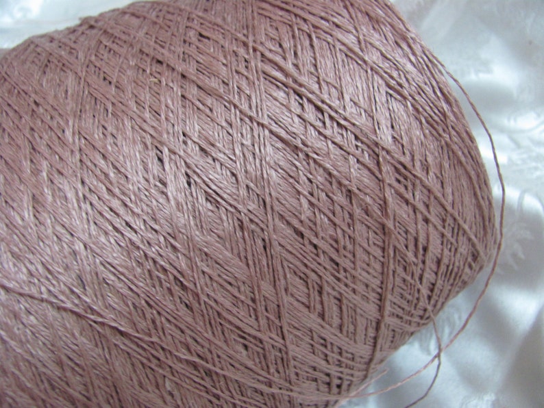 Puede incluir: Un ovillo de hilo de color marr&oacute;n claro, enrollado en forma de bola.