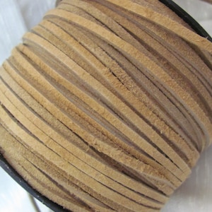 May include: A spool of light brown leather cord. The cord is wound tightly around a black spool.