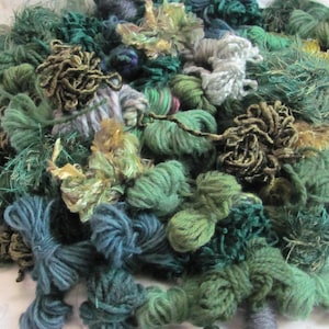 Peut inclure: Un assortiment de fils de couleur verte, bleue et dorée. Le fil est de différentes textures et nuances de vert.