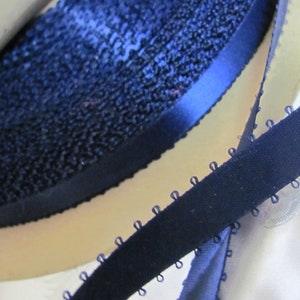 May include: Two navy blue ribbon trims, one with a smooth satin finish and the other with a textured, looped edge.