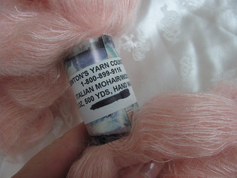 K&ouml;nnte beinhalten: Ein Kn&auml;uel blassrosa Mohairgarn mit einem Etikett mit der Aufschrift "Enton's Yarn Count 1-800-899-9116 Italian Mohair/Wool 1 oz, 500 yds, Hand Washed"